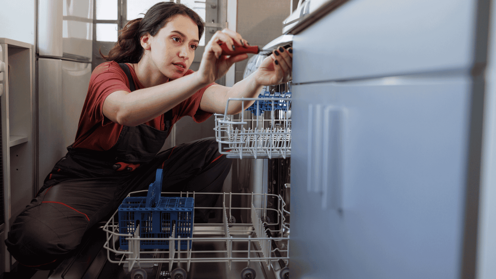 Eine Servicetechnikerin beim Reparieren eines Geschirrspülers